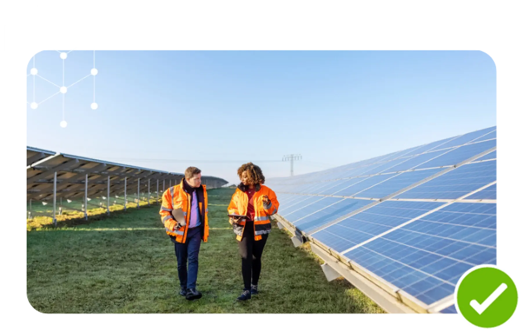 An image of two people walking near solar panels.